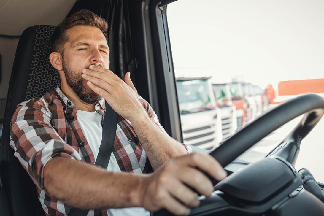 A person yawning while driving a truck

AI-generated content may be incorrect.